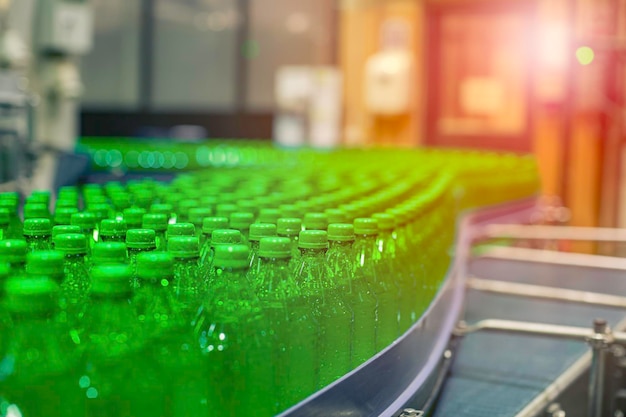 Beverage factory interior Conveyor flowing with bottles green for water