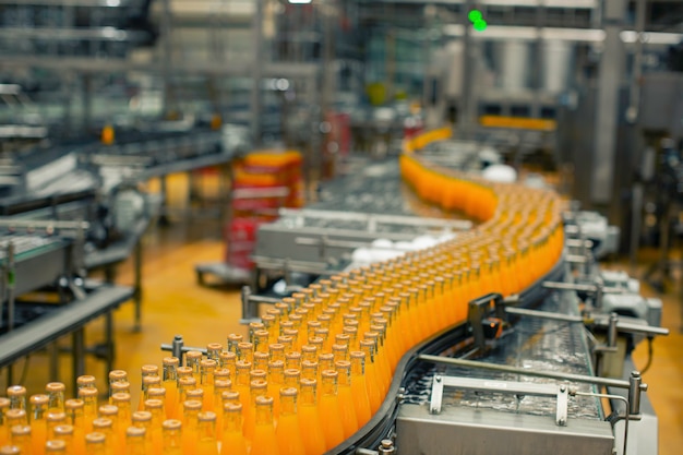 Beverage factory interior. Conveyor flowing with bottles for juice or water.