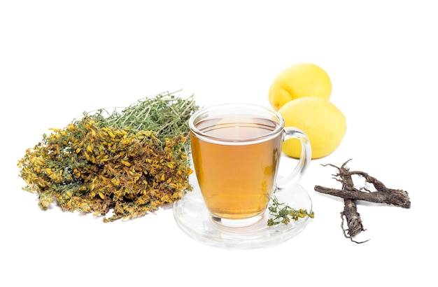 Beverages A glass cup of fresh hot herbal tea and lemons on a white background closeup