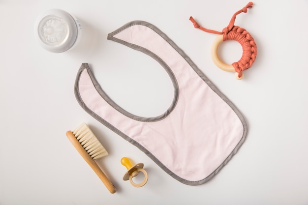 Bib; brush; pacifier; toy and milk bottle on white background