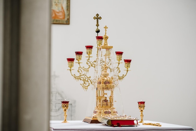 Bible with candles in a candlestick on the table in the church in front of the altar Candles burning near the altar Interior of the Russian Orthodox Church