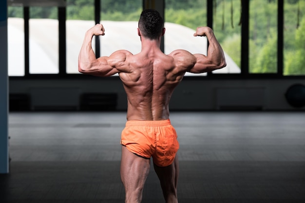 Biceps Pose Of A Young Man In Gym