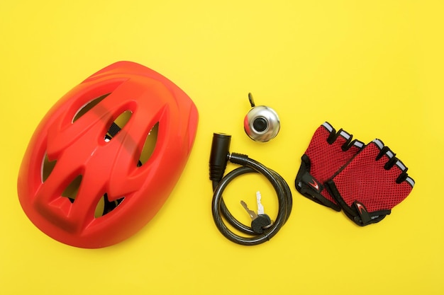 Bicycle accessories helmet bell lock with keys gloves on a yellow background