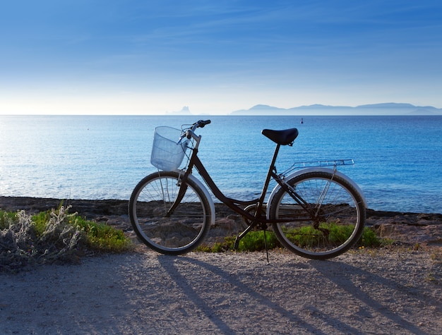 Bicycle in formentera beach with Ibiza sunset