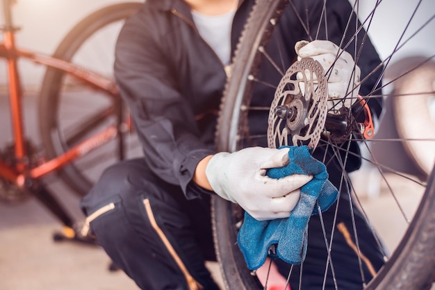 Photo bicycle maintenance rider is wiping the bike clean closeup