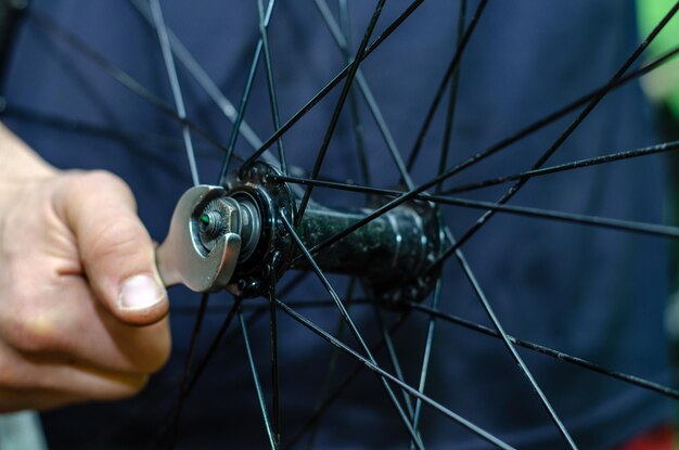 Bicycle repair Replacing the lubrication and cleaning of bicycle hub bearings In the hands of the master professional keys Hardworking hands closeup