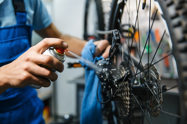 Bicycle repair in workshop, man cleans star cassette closeup