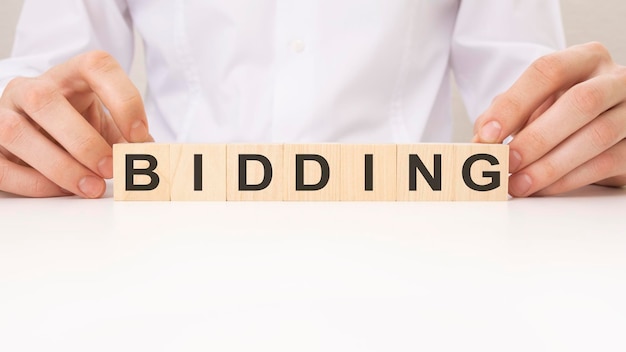 BIDDING word on wooden block white background