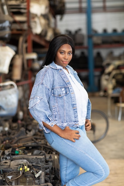 Big african american woman modeling Old Machine auto parts in warehouses Auto mechanic car service repair and maintenance concept used carauto mobile spare parts