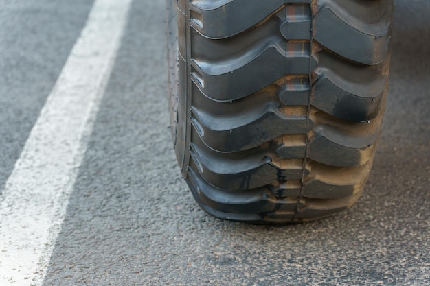 Big black truck tire closeup Exhibition of new largesized equipment Cars for cargo transportation Equipment for working in a quarry