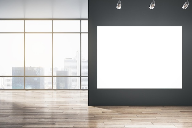 Big blank white illuminated billboard with space for your advertisement on black wall in sunlit empty hall with wooden floor and city skyscrapers view from panoramic window 3D rendering mockup