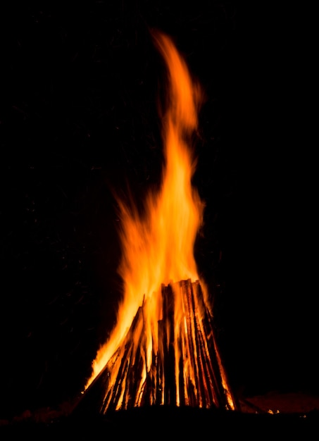 Big bonfire against dark night sky.  Fire flames on black background