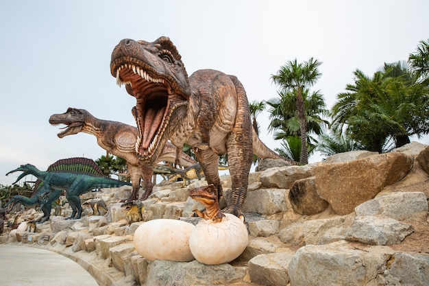 Big brown dinosaur statue on the rock in the park asia Thailand