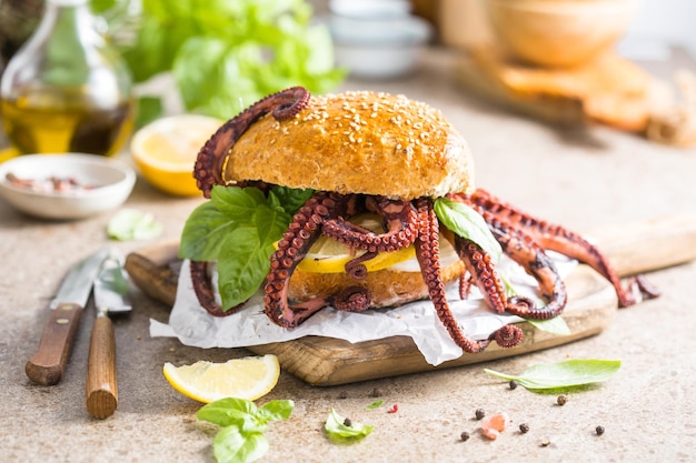 Big burger with octopus and lemon Large sandwich stuffed with seafood American fast food concept