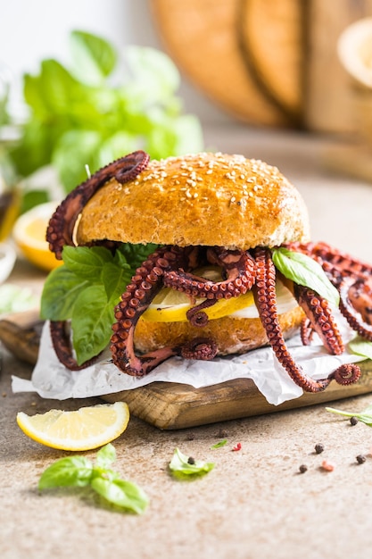 Big burger with octopus and lemon Large sandwich stuffed with seafood American fast food concept