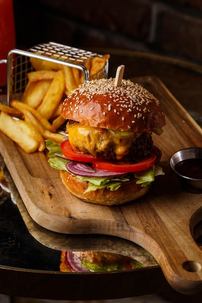 Big cheeseburger with french fries isolated on white background Hamburger with beef patty onion tomato lettuce pickles melted cheddar mustards tomato jam mayo