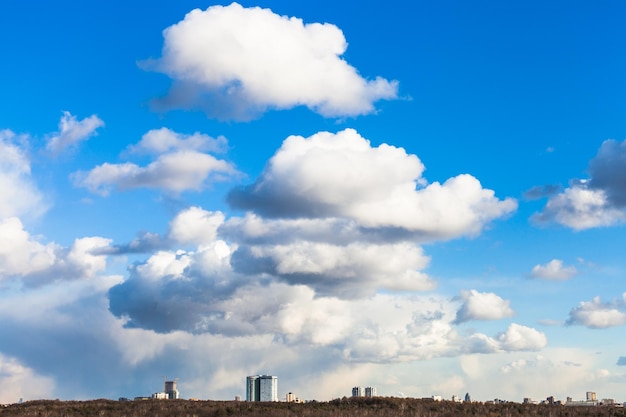 Big clouds in blue sky over urban houses