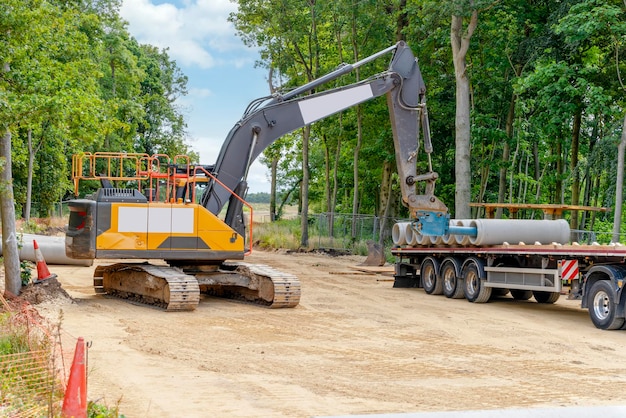 Big diameter concrete pipes for drainage works delivered  and offloaded by excavator