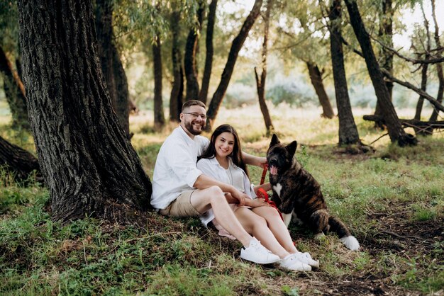 Big dog for a walk with a guy and a girl on the green prairie