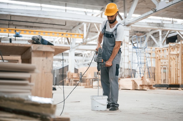 Big drill Industrial worker in wooden warehouse