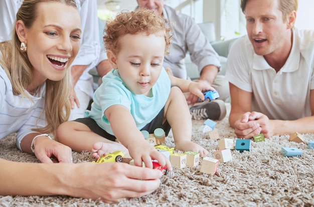 Big family in living room with baby play with toys and fun together on floor on a weekend Happy grandparents mother and father with boy for development in their family home sitting on the ground