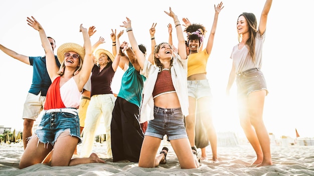 Big group of people having fun dancing on beach party