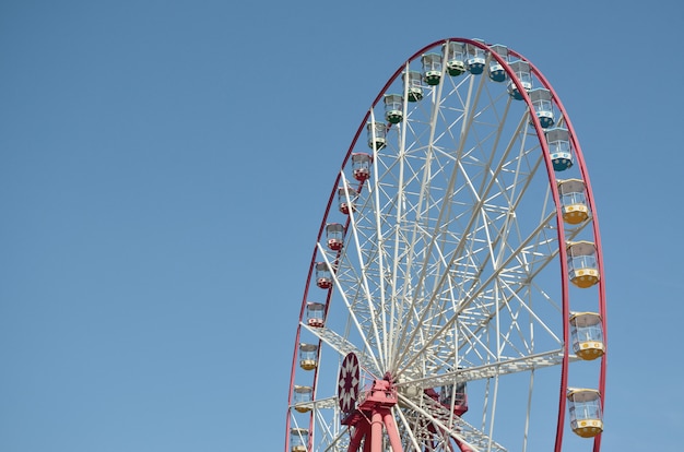 Big and modern multicolour ferris wheel on clean blue sky