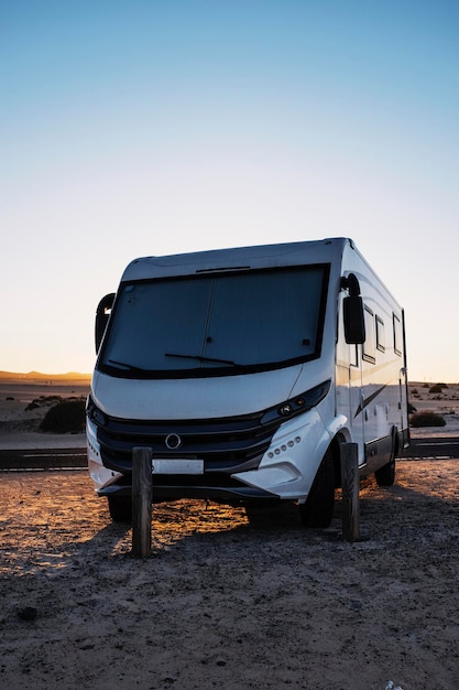 Big motorhome camper parked off road with desert and blue sky in background Travel lifestyle