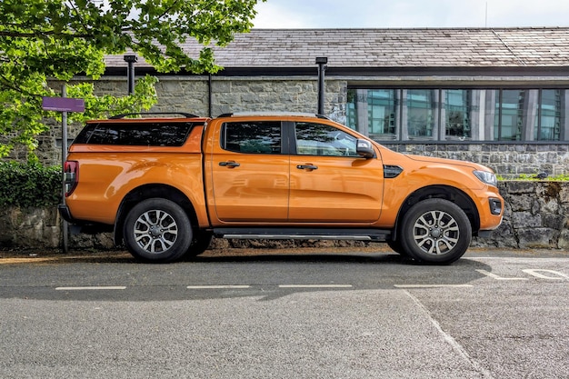 Photo big orange vehicle truck parked under green tree transportation automotive background