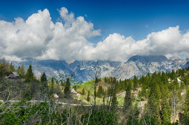 Big Pasture Plateau in Alps, Slovenia. Mountain cottage hut or house on green hill. Alpine landscape