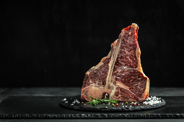 Photo big raw t-bone or aged wagyu porterhouse grilled beef steak with spices ready to cook