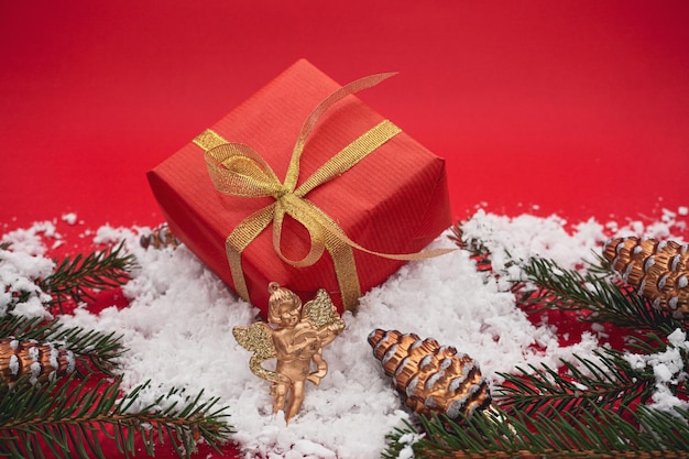 A big red Christmas gift box lies on the snow.