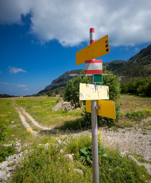 Big signpost with different directions standing on start of tourist route