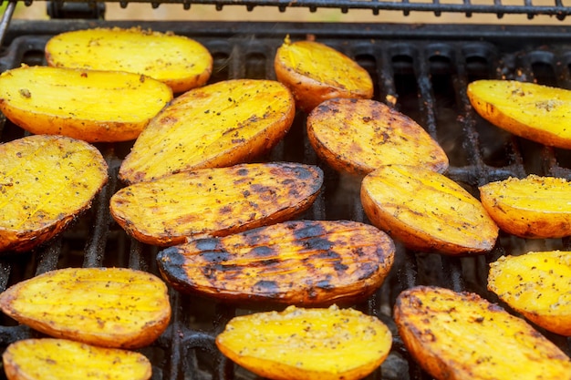 Big Slice Of VillageStyle Potatoes On Hot BBQ Charcoal Grill Flames of Fire In The Background