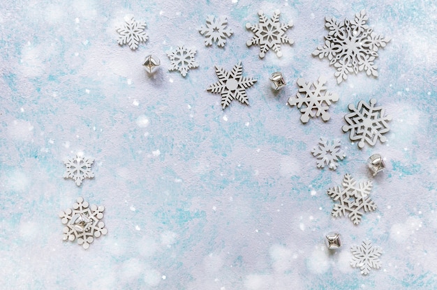 Big and small snowflakes on turquoise blue background. Abstract Christmas and New Year background. Space for text. Soft focus. Top view.