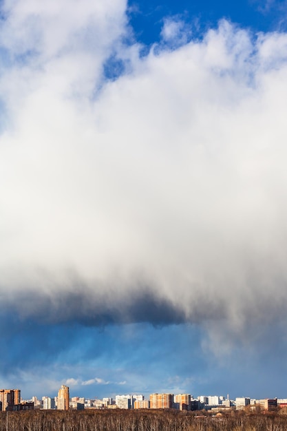 Big snow cloud over town and forest