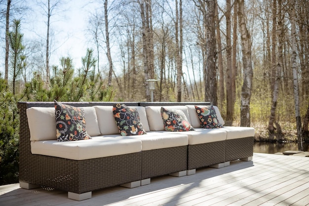 Big sofa, sitting waiting area outdoor, patio furniture, terrace and couch with pillows. spring sun