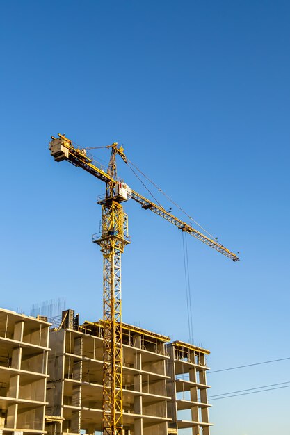 Big steel crane on construction site of residential building