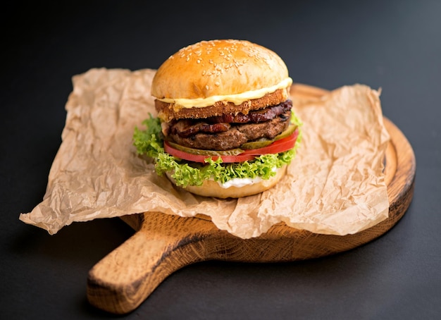 Big tasty burger with beef cutlet on a black background