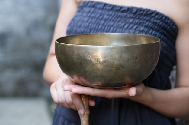 Big Tibetan singing bowl in the hands of a woman