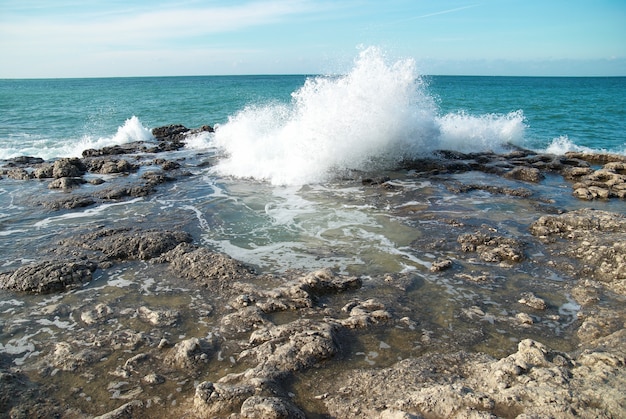 Big waves breaking on the shore with sea foam