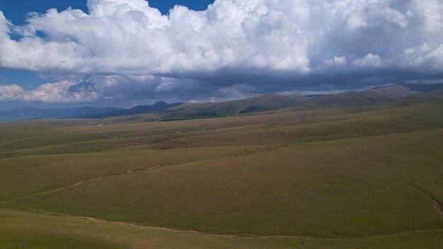 Big white clouds over green hills and mountains