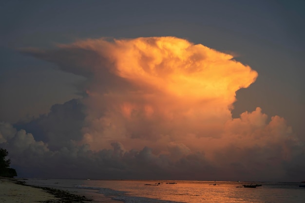 Big white clouds and sky over sea water on tropical beach during sunrise on the island of Zanzibar Tanzania Africa Travel and nature concept