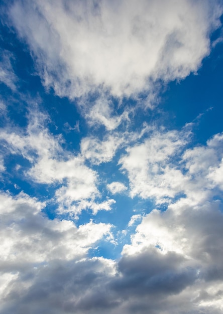 Big white fluffy clouds in the blue sky in sunny weather