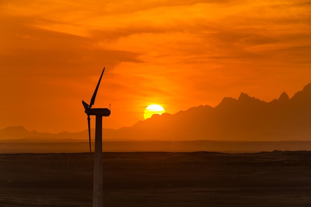 Big wind turbines in the desert against mountains