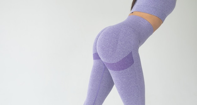 A big woman booty in leggings on grey background.