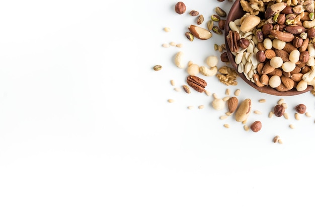 big wooden plate with a mix of useful nuts on a white background