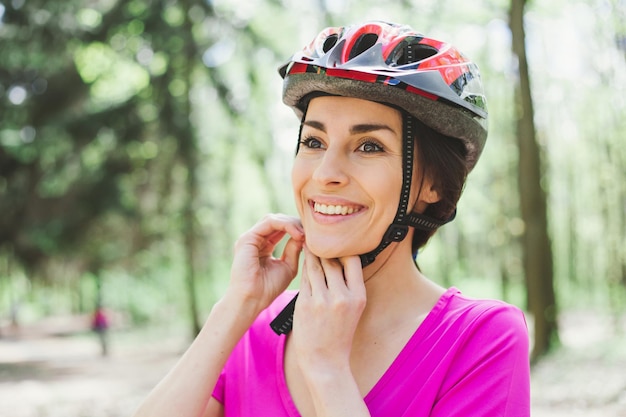 Bike helmet Woman Putting Biking Helmet on Outside During Bicycle Ride