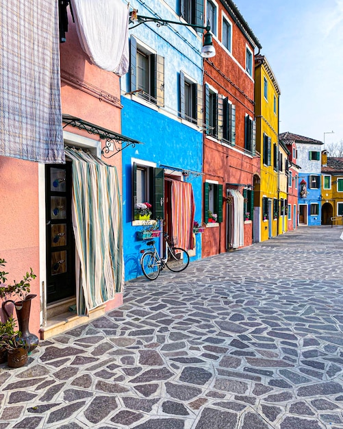 Bike placed on the facade of a multicolored house in Burano island Venice