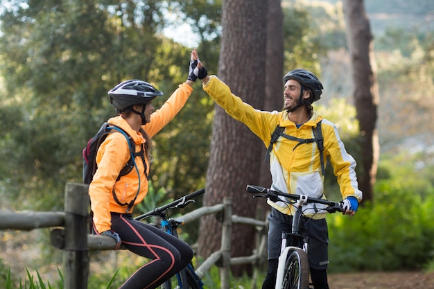 Biker couple giving high five to each other in countryside